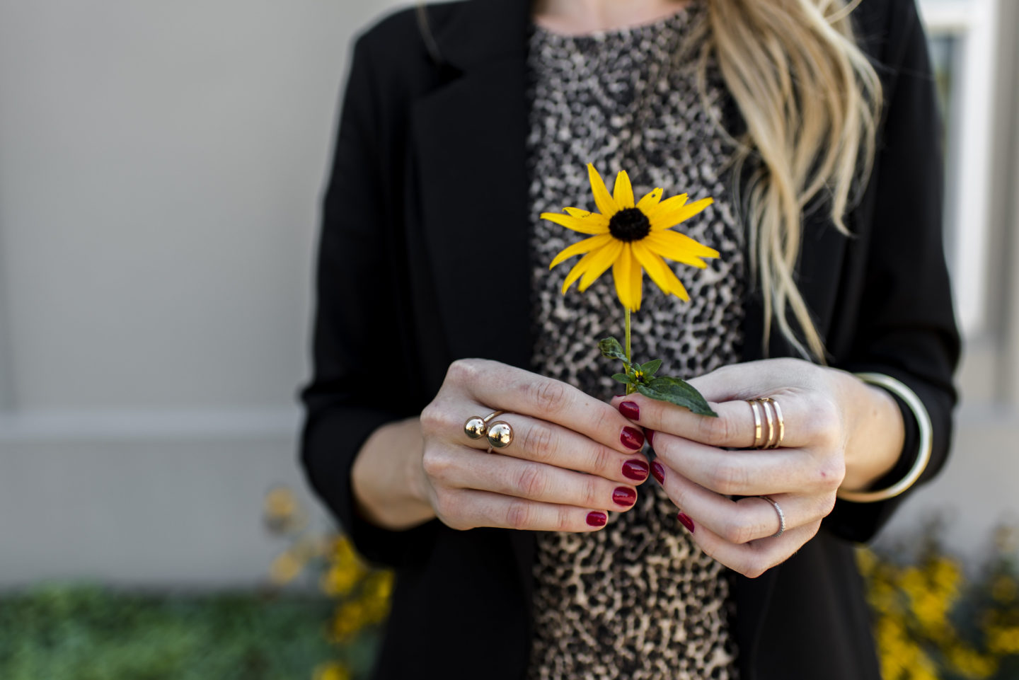 woman holding flower with red nails 