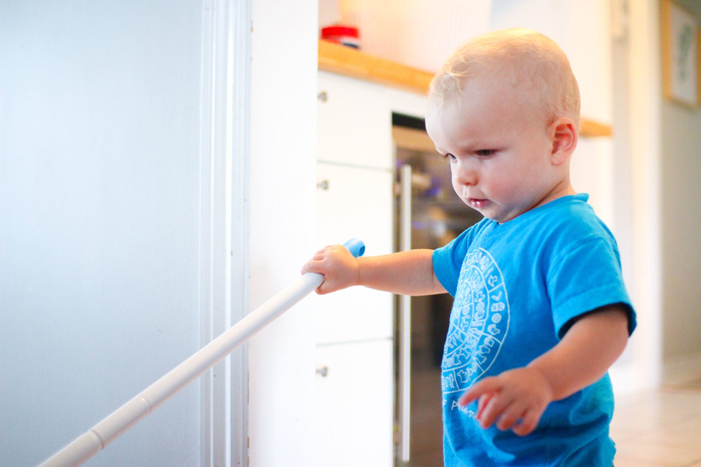 Toddler mopping the floor exhibiting Montessori education in the home.