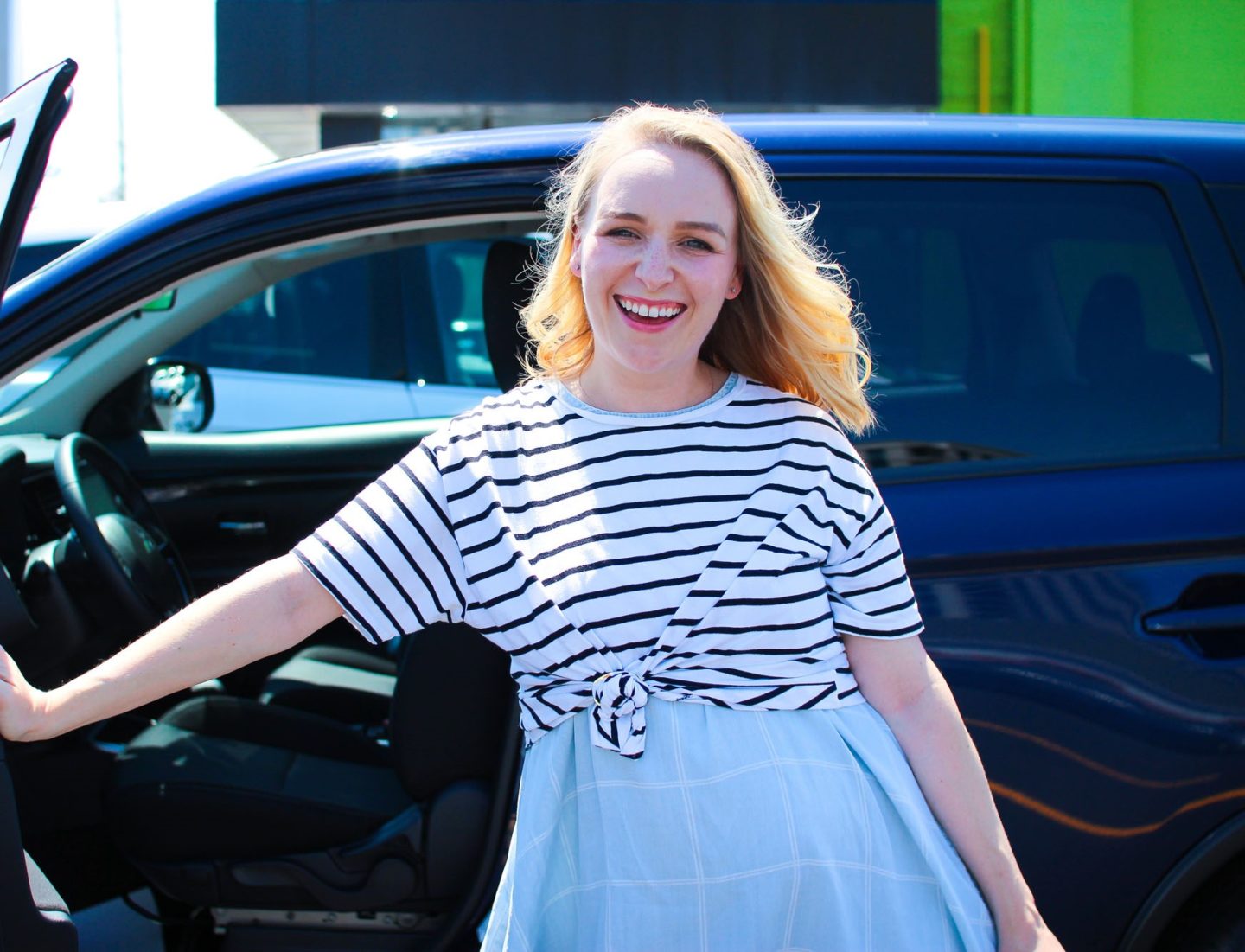 woman exiting car door smiling 