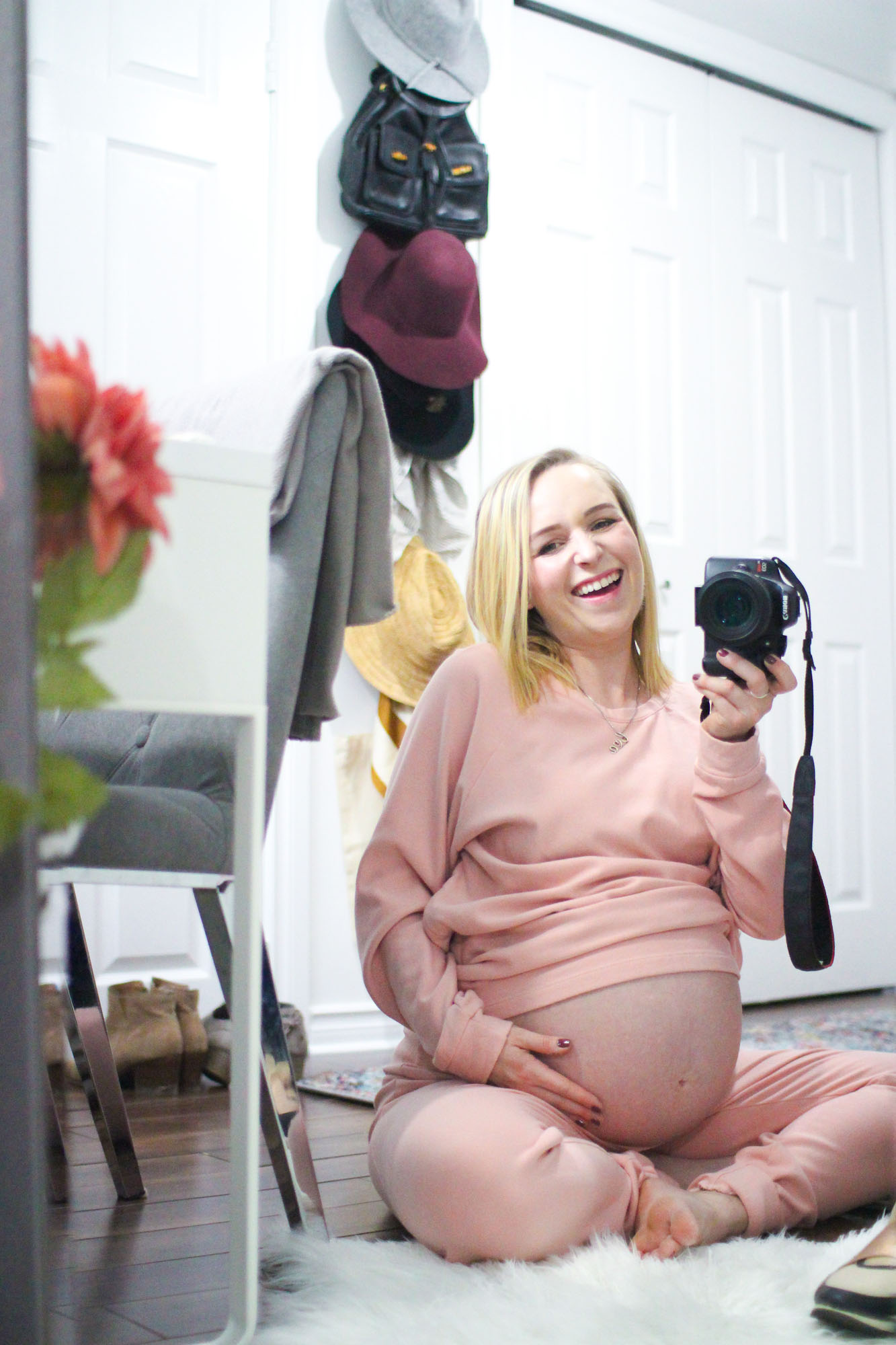 pregnant blogger struckblog sitting with exposed bump in sweatsuit 