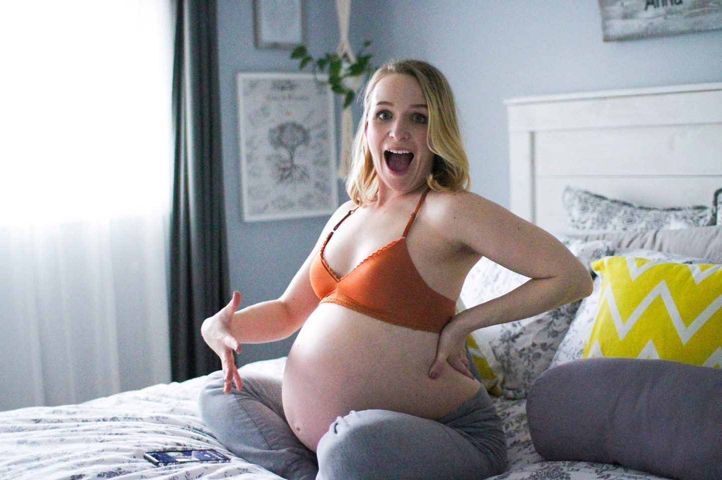 pregnant blogger struckblog sitting on bed with exposed belly