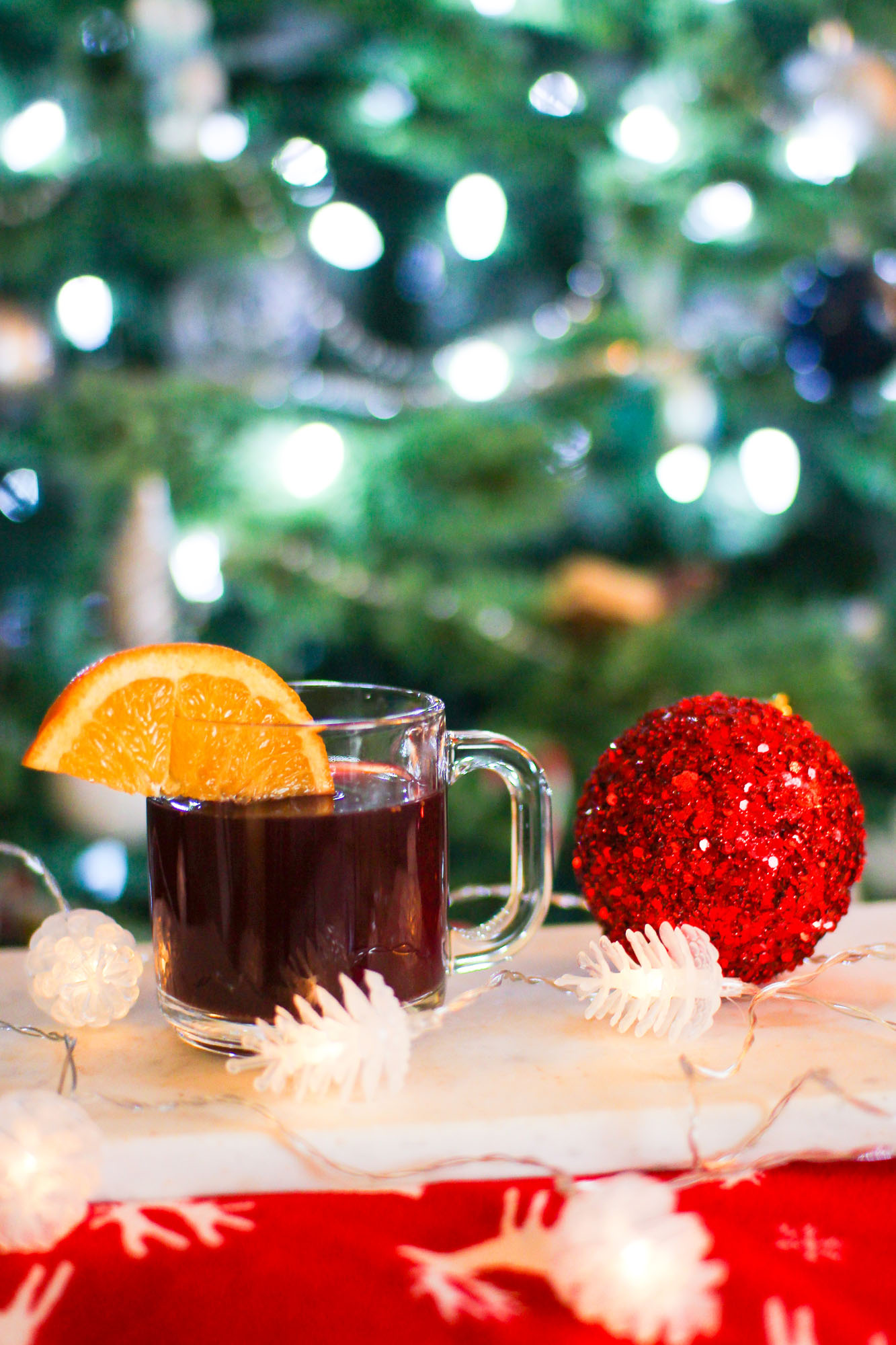 mulled wine in a mug in front of a Christmas tree